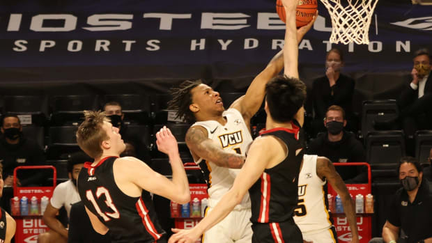 Mar 6, 2021; Richmond, Virginia, USA; VCU Rams guard Adrian Baldwin Jr. (1) shoots the ball as Davidson Wildcats forward Hyunjung Lee (1) defends in the second half in a semifinal of the Atlantic 10 conference tournament at Stuart C. Siegel Center. Mandatory Credit: Geoff Burke-USA TODAY Sports